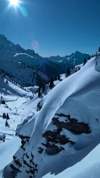Vertical video: Panning drone camera revealing snow ridge with cornices above valley to show peaks