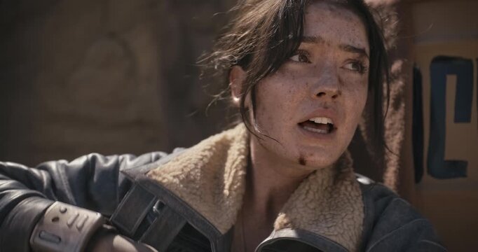 Filthy, sore young woman trying to rest in sci-fi area while playing fetch with off-screen creature