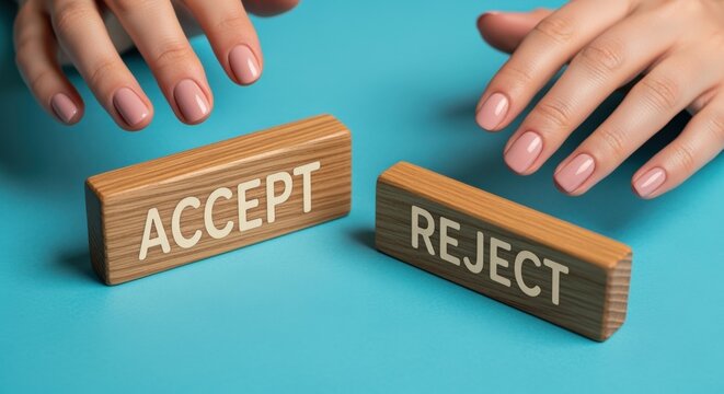 Decision making concept with hands hovering over wooden blocks labeled ACCEPT and REJECT