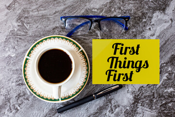 First Things First Motivation Concept with Coffee Cup Glasses and Pen on Marble Desk Background