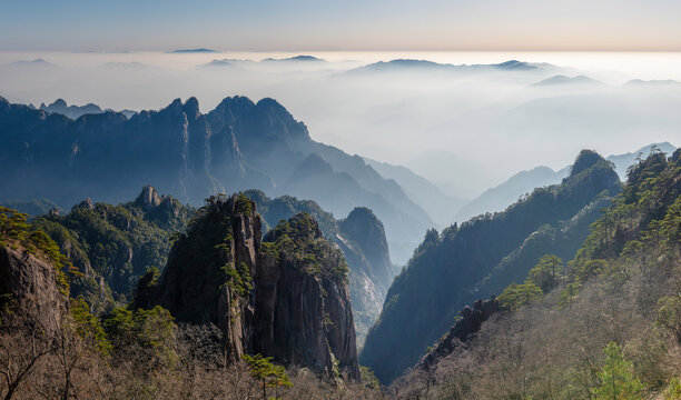 View of the majestic granite peaks and ancient pine trees of the Yellow Mountain rising above a thick sea of clouds Huangshan City, Anhui, China.