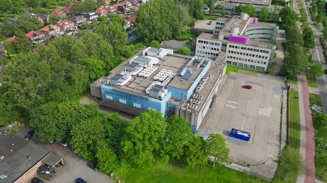Aerial approach small data center near modern office and industrial buildings in suburban business district in Netherlands
