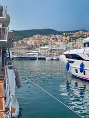 Obraz premium Yachts and sailboats moored in Porto Antico marina with a cruise ship and Genoa skyline against blue sky, Italy