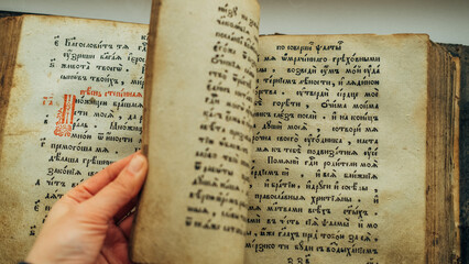 Naklejka premium Old Bible book. Close-up of ancient religious text written in ancient Slavic letters, Cyrillic.
