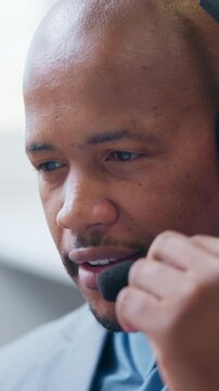 Man, headset and talking in call center for telemarketing, finance advice and problem solving. Black person, insurance agent and mic in office for communication, policy FAQ and outbound calls