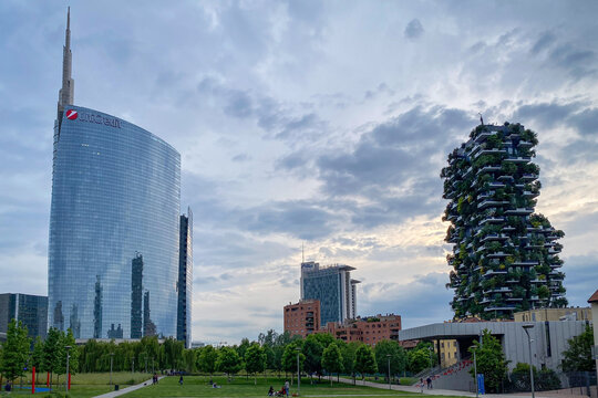 Milan, Italy - May 18, 2023: View of UniCredit Tower and Bosco Verticale above a city park in Porta Nuova against blue sky with clouds in the afternoon