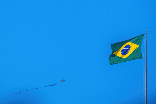 View of the Brazilian flag waving on a tall flagpole against a bright and clear blue sky Rio de Janeiro, State of Rio de Janeiro, Brazil.
