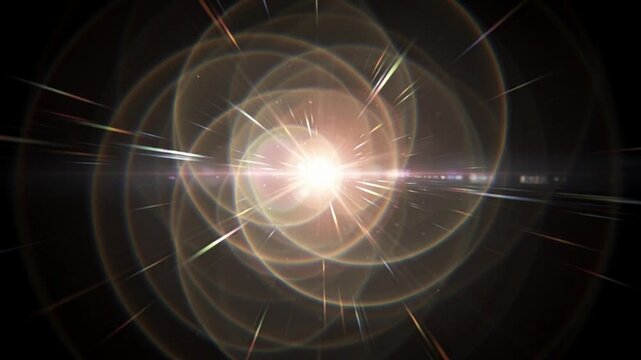 Abstract golden spiral lens flare glowing on black background.