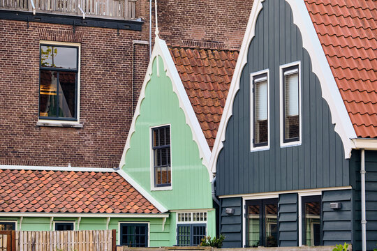 Wormerveer, Netherlands - 06 May 2026: View of two back gables of restored traditional wooden Zaan houses from the 17th century with white trim and orange tiled roofs.