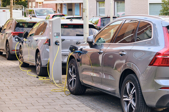 Wormerveer, Netherlands - 06 May 2026: View of electric cars plugged into a Total Energies street charging station with yellow cables on a sidewalk in a residential area.