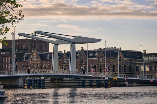 Wormer, Netherlands - 06 May 2026: View of the new Zaanbrug drawbridge over the Zaan river with historic brick architecture and soft sunset clouds.