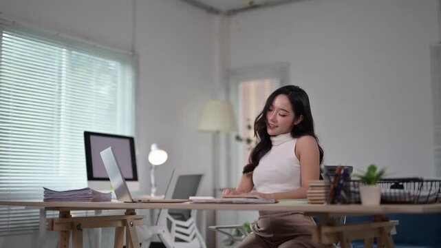 Young businesswoman stretching at office desk