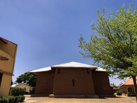 Zaria, Nigeria - 22 March 2026: View of the historic St. Bartholomew's Church in Wusasa featuring traditional mud walls and a cross-shaped window under a clear blue sky.