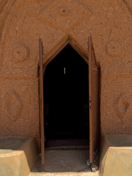 Zaria, Nigeria - 22 March 2026: View of the traditional mud architecture of Wusasa with an open doorway and geometric wall patterns.