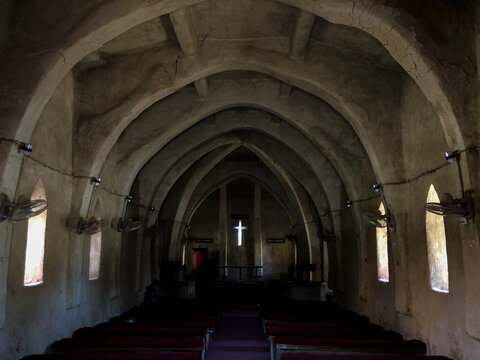 Zaria, Nigeria - 22 March 2026: View of the interior of St. Bartholomew's Church in Wusasa with its unique mud-built arched ceiling, rows of pews, and a glowing cross at the altar.