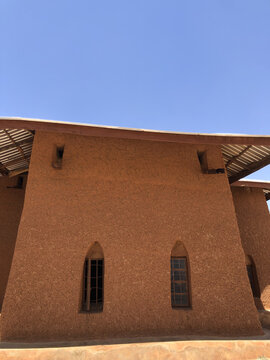 Zaria, Nigeria - 22 March 2026: View of the historic mud-walled St. Bartholomew's Church in Wusasa with its distinctive arched windows and textured earth facade under a clear blue sky.