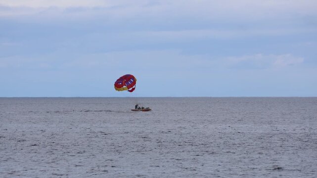 Parasailers Return To Boat In Pacific Ocean With Horizon