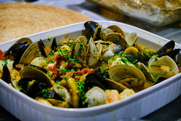 Clams and mussels cocked in a ceramic dish. © Ivan