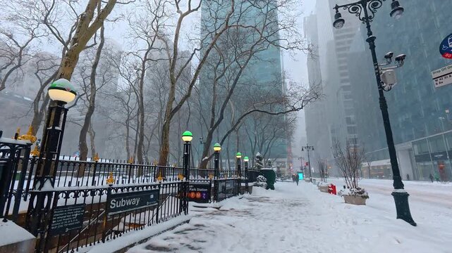 Snow covered New York subway entrance near Bryant Park. A snow packed sidewalk and entrance to a subway station next to Bryant Park during a heavy winter blizzard.