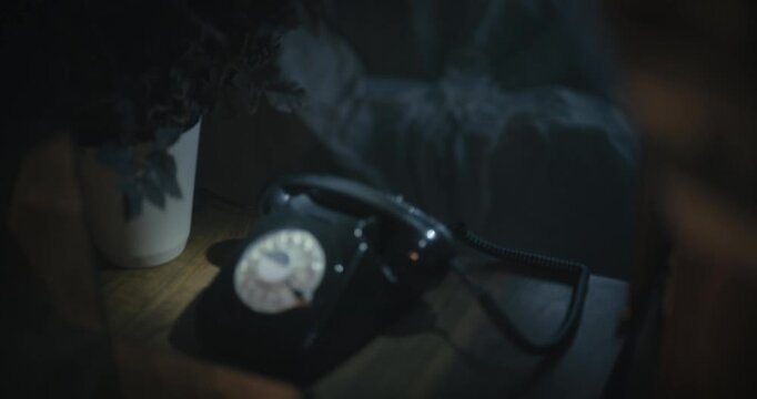 Cinematic tilt shot from rotary phone to blonde woman as she talks in spooky room