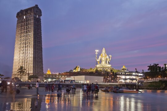 Giant statue of Lord Shiva and a Gopura tower, also Gopuram tower, Murudeshwar Temple at dusk, Murudeshwar, Karnataka, India
