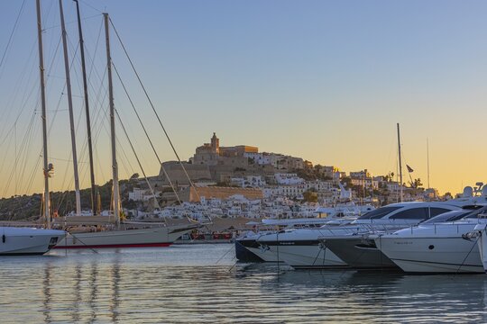 Luxury yachts anchored in the harbour, behind the fortress and the old town of Eivissa, Ibiza Town, Ibiza, Balearic Islands, Mediterranean Sea, Spain