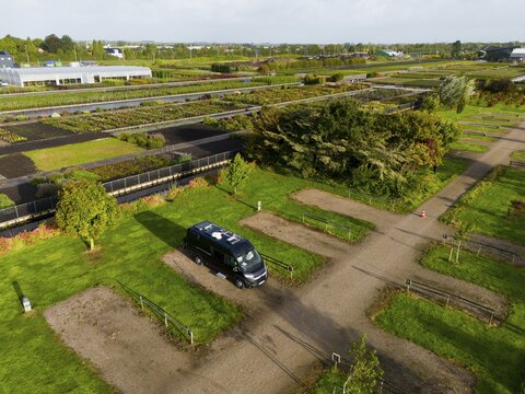 View of a garden with a parked car and surrounding nature, camper, motorhome site, campsite, situated between two canals, Boskoop, province South Holland, Zuid-Holland, Netherlands