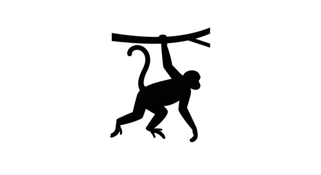 A monkey hangs upside down from a branch in the forest.