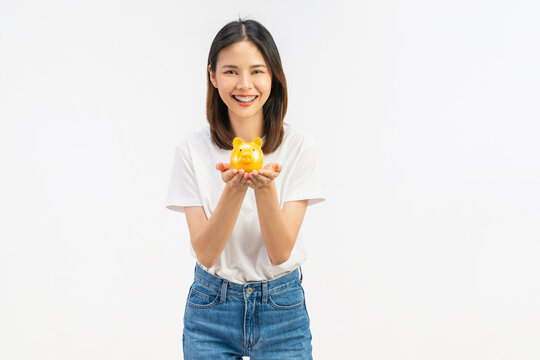 Happy young Asian woman holding a piggy bank and smiling isolated on white studio background for saving money concept.