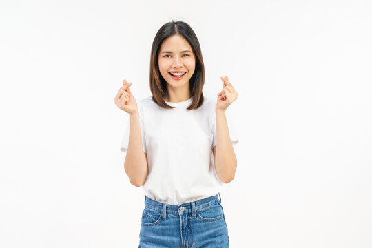 Happy young Asian woman making finger heart gesture and smiling isolated on white studio background.