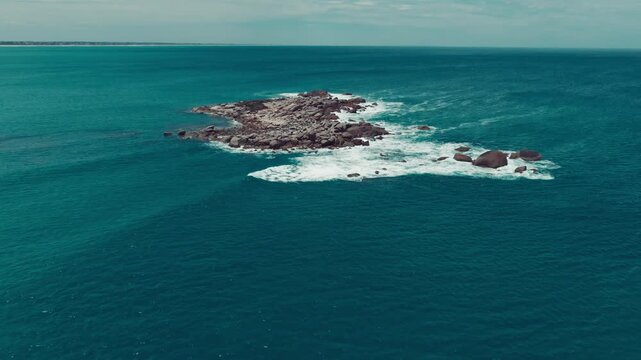 Aerial view of a rocky outcrop near Port Elliot Beach with turquoise water and crashing waves in Port Elliot, South Australia, Australia.