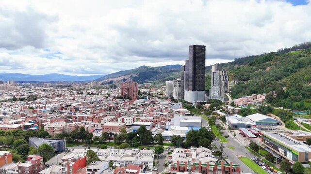 This scene captures sprawling Bogot&aacute; with modern skyscrapers juxtaposed against traditional buildings beneath a cloudy sky.