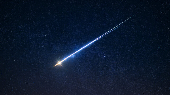 A brilliant meteor streak with a glowing tail in a star-filled night sky.