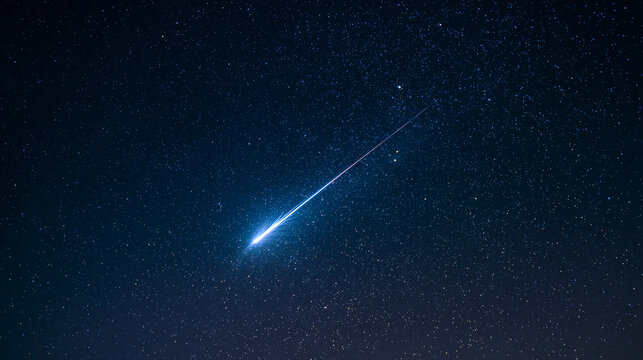 A brilliant meteor streak with a glowing tail in a star-filled night sky.