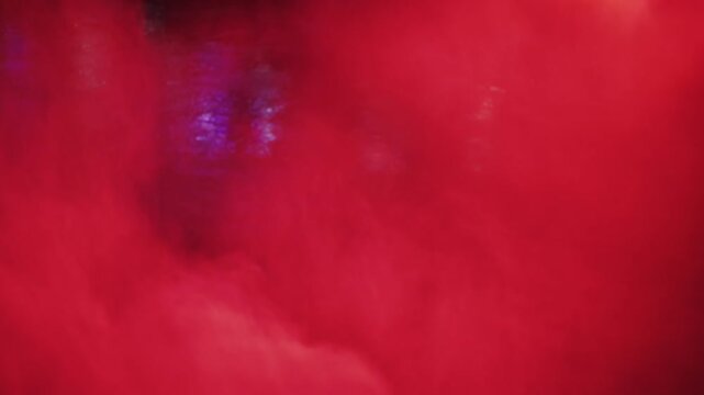 Abstract dynamic swirling colored smoke clouds fill frame, motion background with vibrant hues.