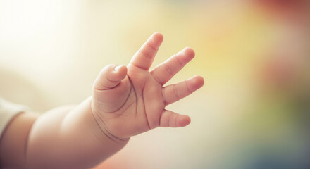 Obraz premium Close up of cute baby hand reaching out, tiny newborn fingers with soft pastel bokeh background, hope and new life concept