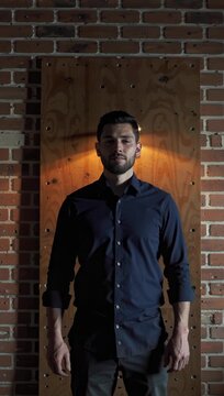 Man in Button-Up Shirt by Brick Wall