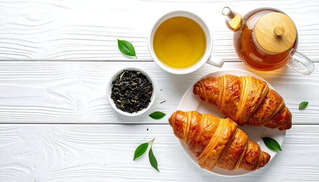 A serene breakfast setup with tea and croissants on a wooden table