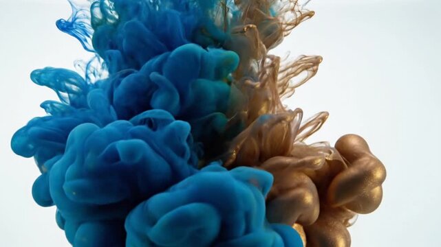 Blue and gold ink clouds mixing.