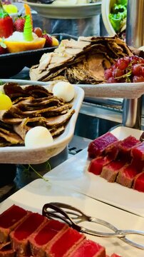 Luxury buffet with smoked salmon, cured beef, basturma, and assorted cold appetizers at a 5-star hotel restaurant. Premium resort dining selection on a sunny terrace in Sharm El Sheikh, Egypt.