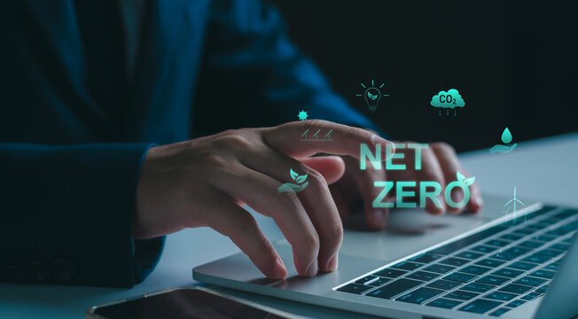 Businessman working on a laptop computer with NET ZERO eco-friendly icons. sustainable environmental concepts, including carbon footprint reduction CO2, renewable energy, and green ecology growth