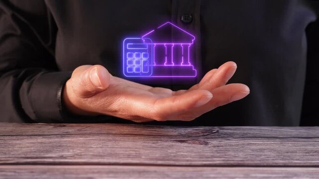 Calculation of interest and loans. Close-up of a woman's hand on a table holding a virtual bank icon with a calculator