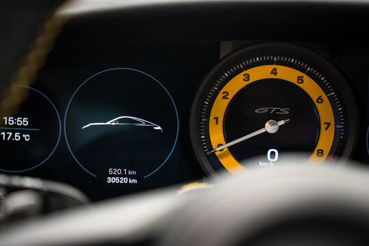 Driver seat view of Porsche 911 Carrera GTS cluster. Right tachometer has yellow ring and GTS script. Left screen shows time, 17.5 C, trip 520.1 km, odometer 30520 km.