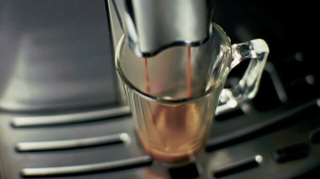 Coffee Machine Pouring Hot Espresso Into Glass Mug. Morning Beverage Preparation