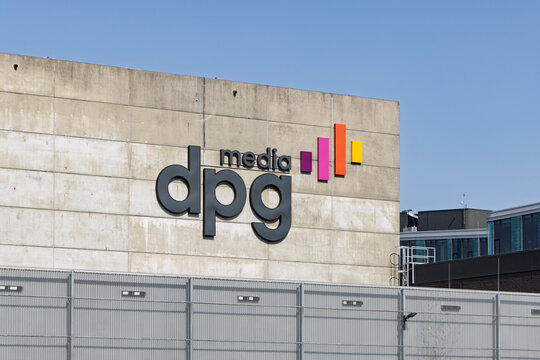 Amsterdam, Netherlands - 23 May 2026 - A close-up view of the DPG Media corporate logo mounted on the concrete exterior wall of their headquarters in Amsterdam on a sunny day.