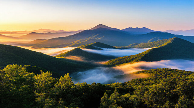 Aerial view of misty mountain valley at golden sunrise with dramatic fog rolling through green forested hills and layered peaks nature landscape scenery travel concept