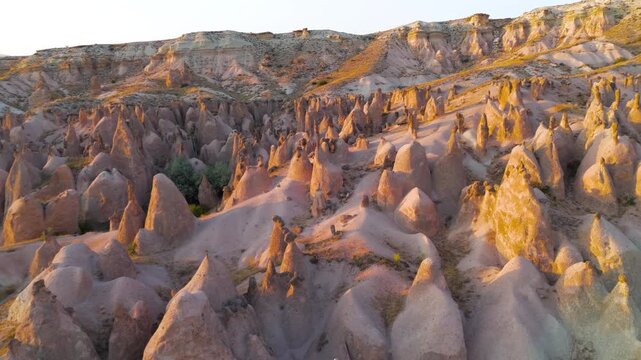 Goreme, Nevsehir, Turkey. Devrent Valley fairy chimneys and hoodoo rock formations, aerial panoramic view at golden hour over the eroded volcanic landscape. Aerial View