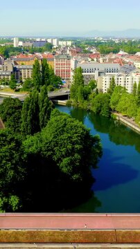 Vertical video. Strasbourg, France. The Vauban Dam, a 17th-century defensive bridge with 13 arches spanning River Ill, Drone footage revealing the Ponts Couverts towers and Petite France quarter, bri