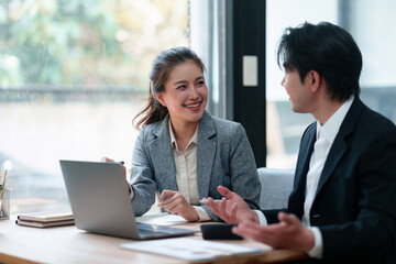 Two young asian business people actively discussing project ideas and strategies during a professional team meeting © Crystal