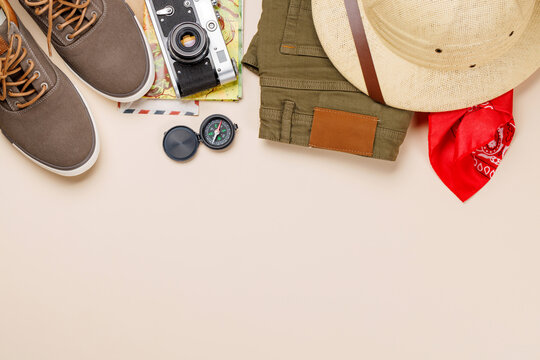 Safari clothing and gear on beige background